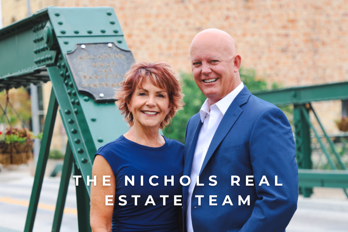 Photo of Scoot & Sandy Nichols of The Nichols Real Estate Team with the "Swinging Bridge" located in the Village of Arroyo Grande in the background. Your local experts in the Arroyo Grande Real Estate Market.